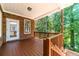 Cozy back porch with wood flooring, brick accents, and a serene view of the wooded backyard at 980 Windsor Place Cir, Grayson, GA 30017