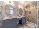 Beautiful bathroom featuring double sinks, stylish mirrors, and a tiled shower with glass doors at 980 Windsor Place Cir, Grayson, GA 30017