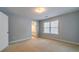 A bright bedroom featuring neutral carpet, pale-blue walls, and natural light from a window at 980 Windsor Place Cir, Grayson, GA 30017