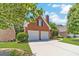 Charming two-car garage with a brick facade, well-maintained landscaping, and a wide driveway, offering ample parking at 980 Windsor Place Cir, Grayson, GA 30017