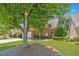 Traditional home featuring a brick exterior, manicured lawn, mature trees, and a welcoming entrance, showcasing curb appeal at 980 Windsor Place Cir, Grayson, GA 30017
