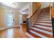 The foyer with hardwood floors, a staircase, and a view into the living room featuring a fireplace at 980 Windsor Place Cir, Grayson, GA 30017