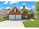 Charming brick home featuring a two-car garage, manicured lawn, and beautiful landscaping at 980 Windsor Place Cir, Grayson, GA 30017