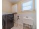 Functional laundry room with washer, sink, storage and natural light at 980 Windsor Place Cir, Grayson, GA 30017
