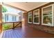 Inviting porch area with a wooden floor, brick columns, and bright natural lighting, perfect for relaxing or entertaining at 980 Windsor Place Cir, Grayson, GA 30017
