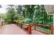 The wooden deck has black metal railings and overlooks the lush green backyard at 1477 Triple Creek Nw Ct, Kennesaw, GA 30144