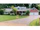 Charming brick and siding home featuring a lush front yard and a welcoming driveway at 1477 Triple Creek Nw Ct, Kennesaw, GA 30144