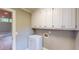 Bright laundry room offers a sink, cabinets, and neutral color palette at 1477 Triple Creek Nw Ct, Kennesaw, GA 30144