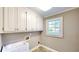 Cozy laundry room with utility sink, ample storage cabinets and tile floors at 1477 Triple Creek Nw Ct, Kennesaw, GA 30144