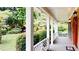 Inviting covered porch with classic white columns and view of landscaped yard at 1477 Triple Creek Nw Ct, Kennesaw, GA 30144