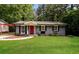 Charming single-story home featuring a red door, painted brick, and a lush green lawn at 3372 Ward Drive Southwest Sw Dr, Atlanta, GA 30354
