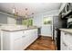Well-lit kitchen with white cabinets, stainless steel appliances, and hardwood floors at 3372 Ward Drive Southwest Sw Dr, Atlanta, GA 30354