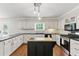 Stylish kitchen featuring white cabinets, black countertops, an island, and stainless steel appliances at 3544 Chestatee Dr, Marietta, GA 30062