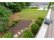 Lush backyard featuring stone steps, mulched garden, lawn, and wooden deck at 3642 Fowler Rdg, Douglasville, GA 30135