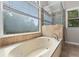 Luxurious bathroom with a garden tub, tile surround, and a separate glass-enclosed shower at 3642 Fowler Rdg, Douglasville, GA 30135