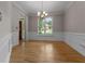 Bright dining area with hardwood floors, crown molding, a chandelier and views of the front yard through large windows at 3642 Fowler Rdg, Douglasville, GA 30135