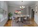 Elegant dining room featuring modern chandelier, light gray walls, wood floors and large windows at 3642 Fowler Rdg, Douglasville, GA 30135