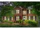 Traditional two-story brick home with black shutters and a manicured lawn and mature shade trees at 3642 Fowler Rdg, Douglasville, GA 30135