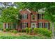 Traditional two-story brick home with black shutters and a manicured lawn and mature shade trees at 3642 Fowler Rdg, Douglasville, GA 30135