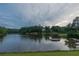 Scenic pond surrounded by lush trees and a hint of a building in the background, creating a serene atmosphere at 3642 Fowler Rdg, Douglasville, GA 30135