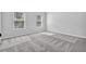 Light-filled bedroom with gray walls, carpet flooring, and two large windows at 4238 Sir Dixon Dr, Fairburn, GA 30213