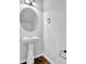 Chic powder room featuring a pedestal sink, decorative mirror, and modern fixtures at 4238 Sir Dixon Dr, Fairburn, GA 30213