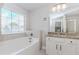 Bright bathroom with a soaking tub, granite counters, and a view at 431 Hinton Farm Way, Dacula, GA 30019