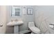 Stylish half bathroom featuring a pedestal sink, designer mirror, and modern geometric wallpaper at 431 Hinton Farm Way, Dacula, GA 30019
