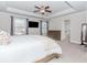 Bright bedroom featuring tray ceilings, a ceiling fan, and access to an ensuite bathroom at 431 Hinton Farm Way, Dacula, GA 30019