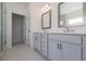 Bathroom featuring double sinks, framed mirrors, white countertops, and neutral tiling at 502 Healy Dr # 76, Cumming, GA 30040
