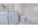 Bathroom featuring gray tiling, a tub, and neutral cabinetry at 502 Healy Dr # 76, Cumming, GA 30040
