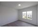 Bedroom with carpeting, bright white walls and trim, and a window offering views of the neighborhood at 502 Healy Dr # 76, Cumming, GA 30040