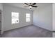 This bedroom features neutral carpeting, crisp white walls, a ceiling fan, and natural light from two windows at 502 Healy Dr # 76, Cumming, GA 30040