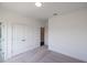 Carpeted bedroom with neutral colors, closet, ensuite bathroom and white doors at 502 Healy Dr # 76, Cumming, GA 30040