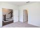 Spacious bedroom with plush carpet, staircase entrance, and bathroom doorway at 502 Healy Dr # 76, Cumming, GA 30040