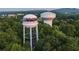 Aerial view of the Cumming water tower and city, showcasing its location surrounded by lush greenery and trees at 502 Healy Dr # 76, Cumming, GA 30040