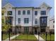 Beautiful townhome with brick accents, dark trim windows, a grassy yard, and a wrought iron fence around the property at 502 Healy Dr # 76, Cumming, GA 30040