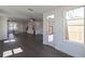 Open-concept living room featuring dark wood floors, a fan, and a door to the deck at 502 Healy Dr # 76, Cumming, GA 30040
