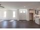 Spacious living room with dark hardwood floors, large windows, and an open layout leading into the kitchen at 502 Healy Dr # 76, Cumming, GA 30040