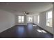 Bright living room features dark wood floors, a ceiling fan, and many windows at 502 Healy Dr # 76, Cumming, GA 30040