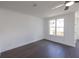 Cozy living room features dark wood floors, a ceiling fan, and a large window at 502 Healy Dr # 76, Cumming, GA 30040