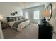 Spacious main bedroom featuring carpet floors, modern decor, and an elegant light fixture at 502 Healy Dr # 76, Cumming, GA 30040