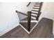 Close-up of the staircase showcasing hardwood steps, a black metal railing, and detailed trim work at 502 Healy Dr # 76, Cumming, GA 30040