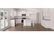 Modern white kitchen featuring granite countertops, stainless steel appliances, and center island, perfect for cooking at 637 Kimberwick Dr, Locust Grove, GA 30248