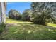 A spacious green backyard featuring mature trees and lawn, plus a patio area, offers a tranquil outdoor setting at 9066 Bob Jackson Dr, Jonesboro, GA 30238