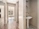 Hallway with a pedestal sink and a view of a room with a window at 9066 Bob Jackson Dr, Jonesboro, GA 30238