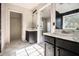 Bathroom featuring dual sinks, marble floors, and black brick-style wall tile at 9066 Bob Jackson Dr, Jonesboro, GA 30238