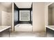 Bathroom featuring a soaking tub, black brick-style wall tile, and marble floors at 9066 Bob Jackson Dr, Jonesboro, GA 30238
