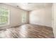 Well-lit bedroom with wood-look floors and two large windows at 9066 Bob Jackson Dr, Jonesboro, GA 30238