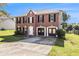 Brick two-story home with a two-car garage and classic design on a lush green lawn at 9066 Bob Jackson Dr, Jonesboro, GA 30238